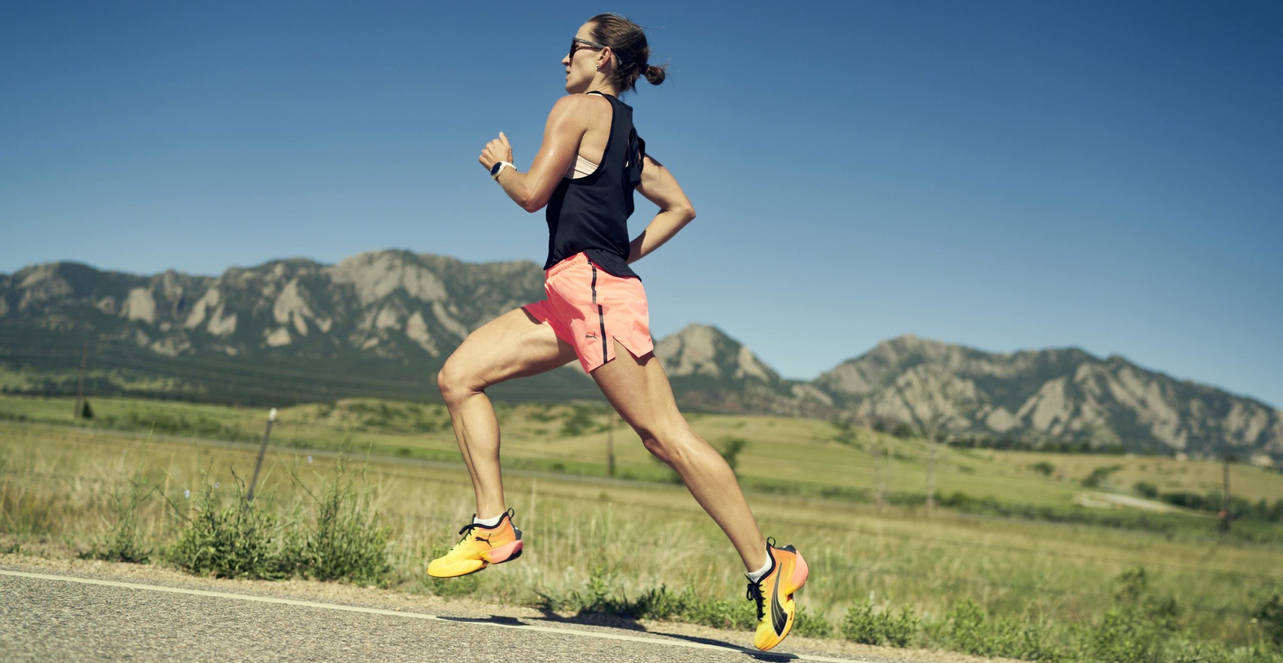 Femme en tenue de running PUMA court dans une région montagneuse