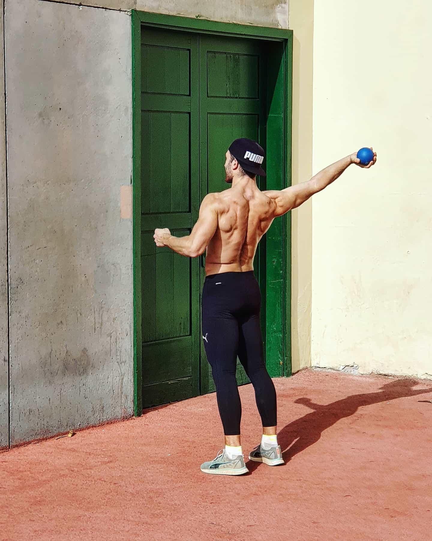 Un homme en tenue de sport est dans une salle de fitness en train de faire des exercices de renforcement du dos