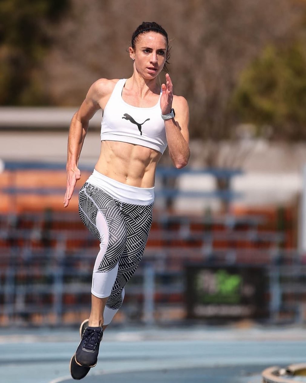 Une femme en tenue de sport PUMA entrain de sprinter