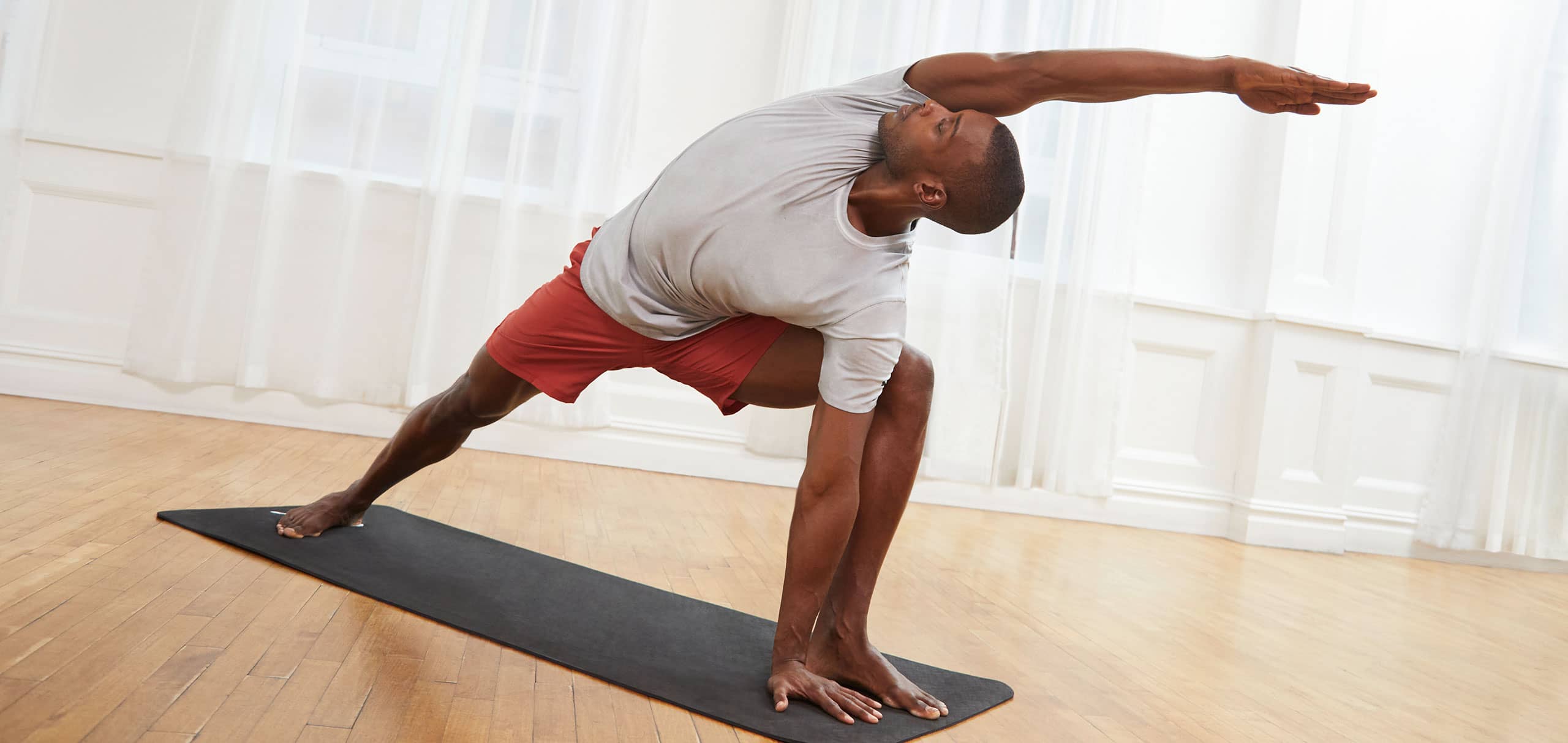 Homme entrain de faire un exercice de flexibilité sur un tapis de yoga