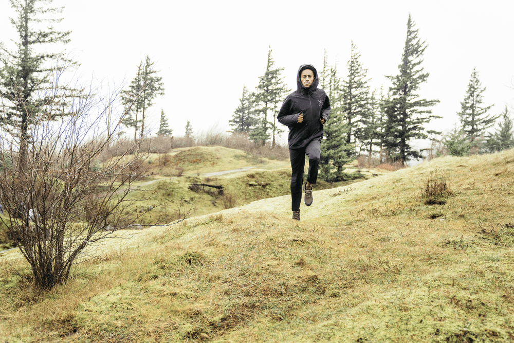 Un homme en tenue de trail PUMA court dans une forêt