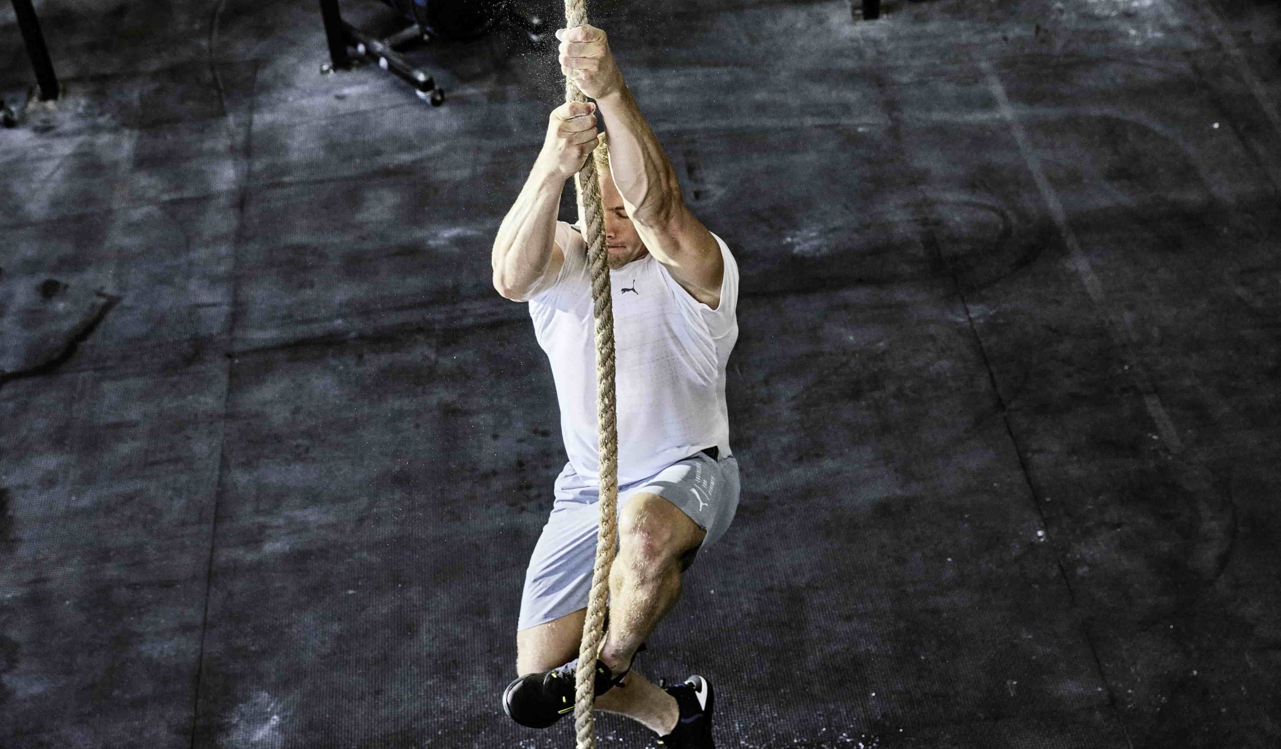 Een bovenaanzicht van een man die in de touwen klimt