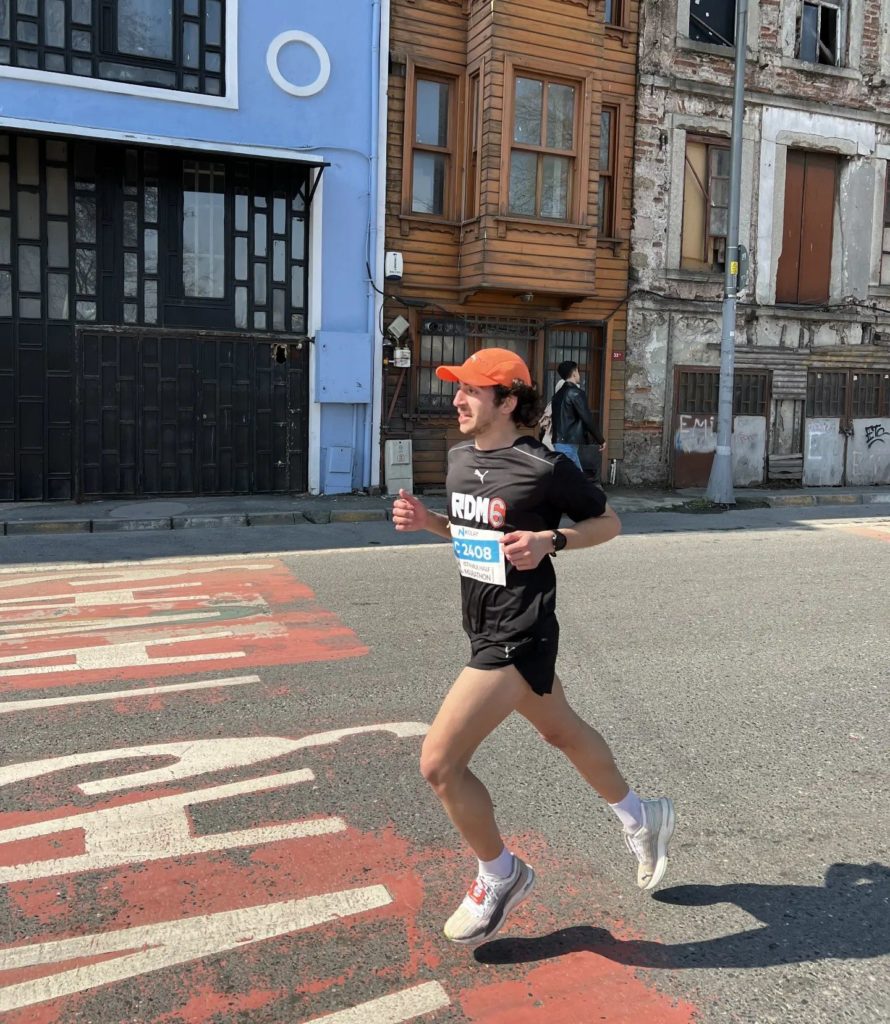 Läufer in schwarzen PUMA Shorts und T-Shirt mit orangenen Cap beim City Marathon