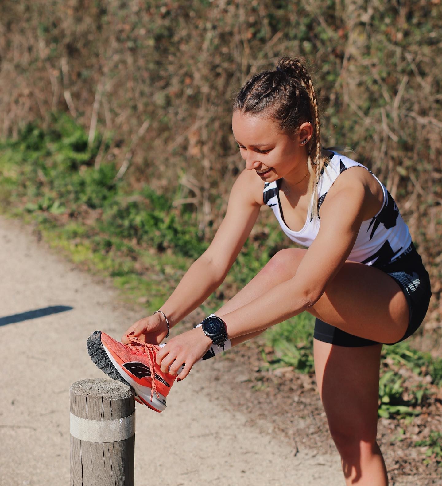 Une femme en tenue de running d’été fait les lacets de ses chaussures de running PUMA