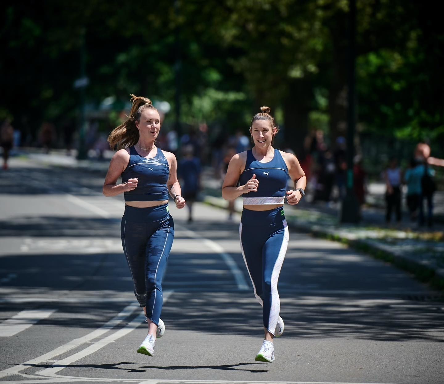 Deux femmes habillées de vêtements de sport PUMA font un footing en rue