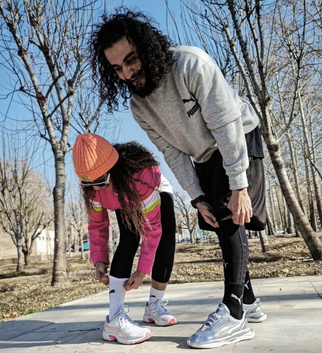 Vater und Tochter in PUMA Laufbekleidung bei Pause während des Lauftrainings im Freien