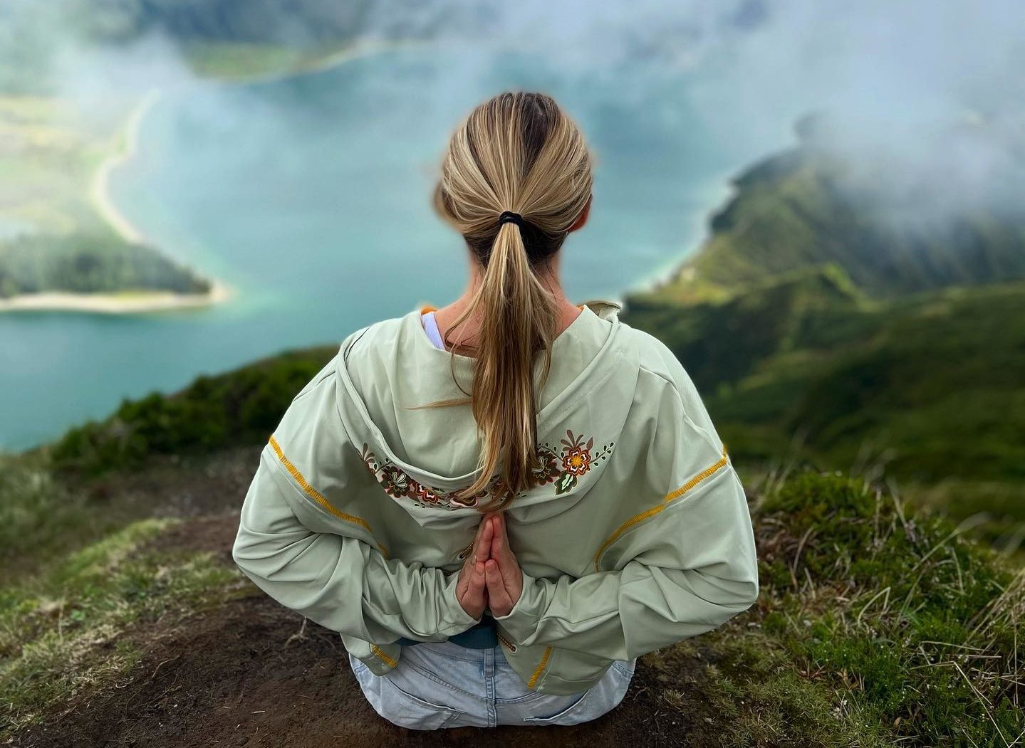 Eva Christopherson en train de méditer, assise sur montagne, les mains dans son dos